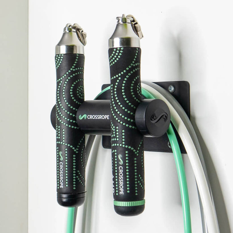 Jump rope wall mount secured to the wall holding the AMP Set from Crossrope.